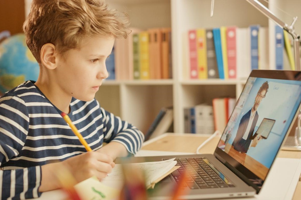 Ein Junge erhält Mathematik-Unterricht über den Laptop